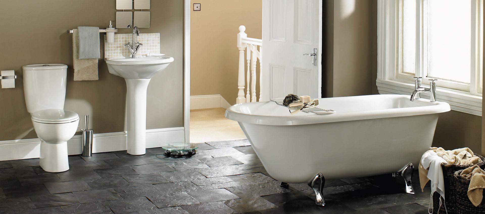 A toilet, a pedestal sink and soaking tub.